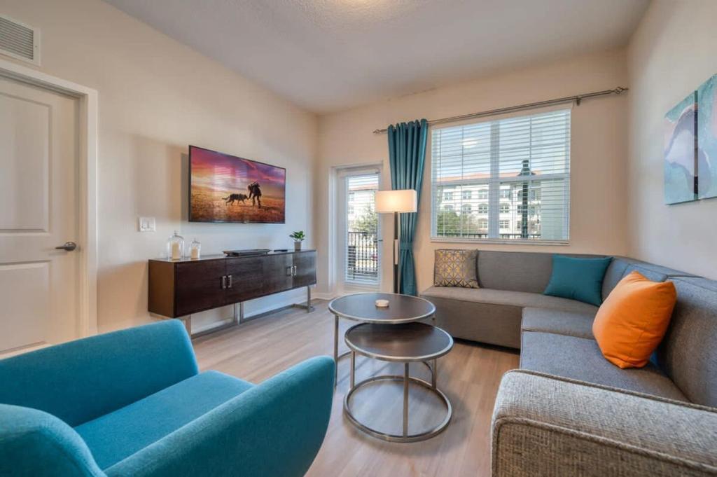 uma sala de estar com um sofá, cadeiras e uma mesa em Prime Location-Spacious Condo for 8 Guests em Orlando