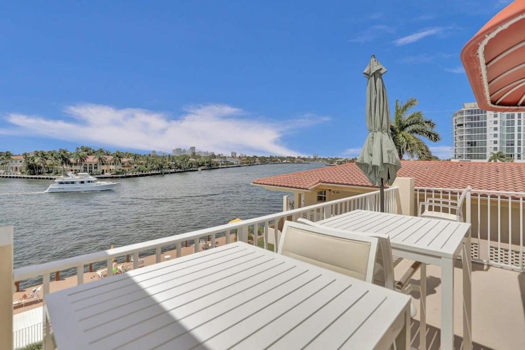 einen Balkon mit einem Tisch, einem Sonnenschirm und einem Boot in der Unterkunft Fort Lauderdale Yacht & Beach Club 412 in Fort Lauderdale