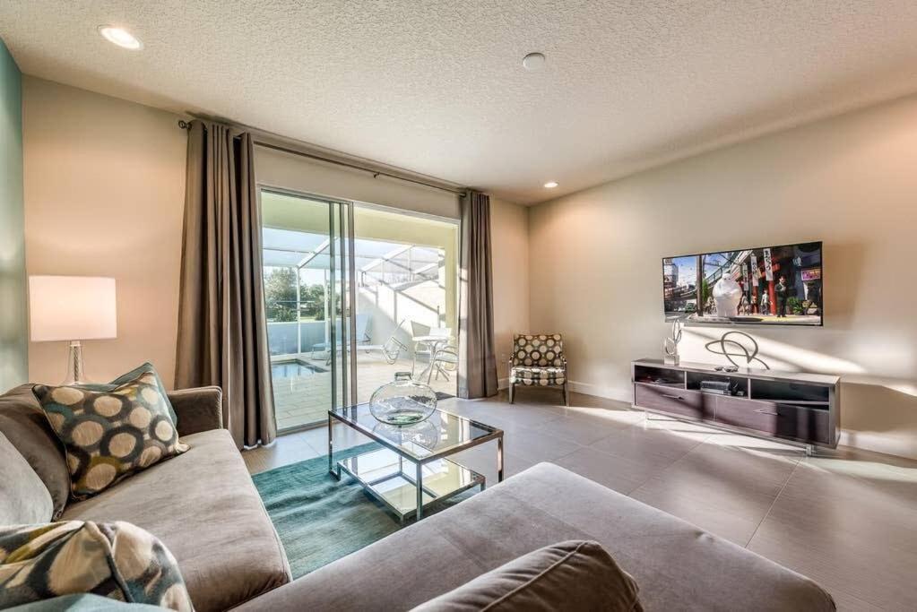 a living room with a couch and a glass table at Super cozy home with private pool in Orlando