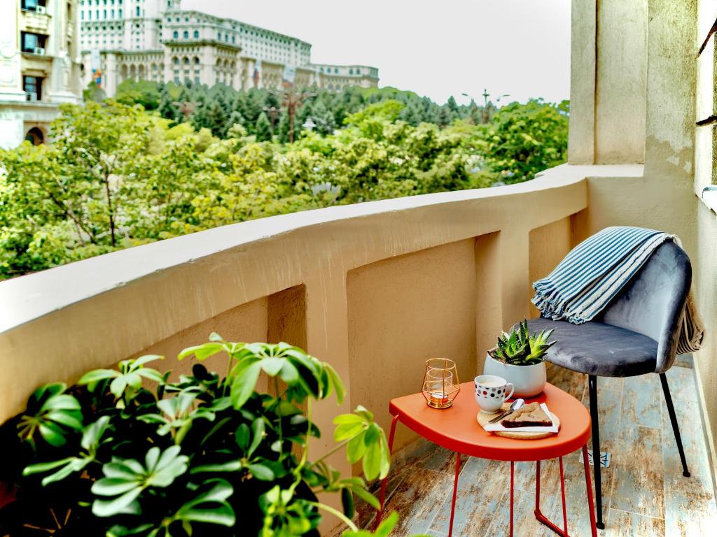 d'une petite table et d'une chaise sur un balcon. dans l'établissement Parliament Pearl - Amazing View - OLD Town, à Bucarest