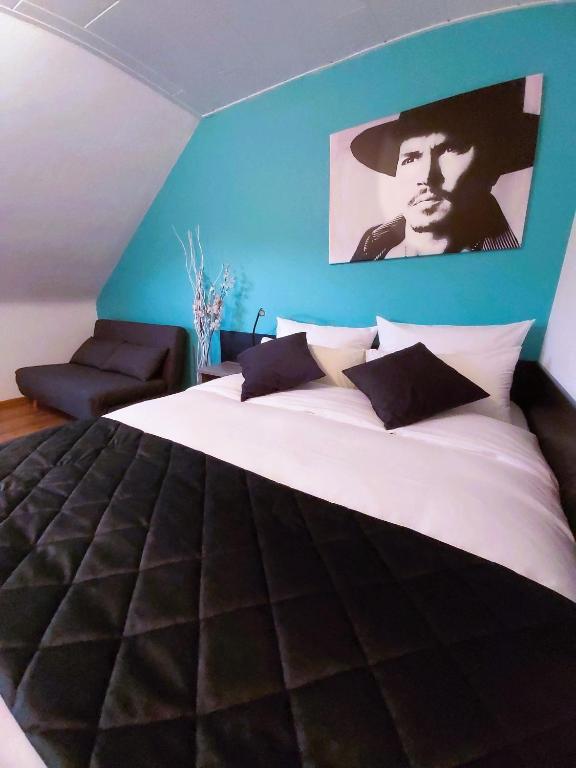 a bedroom with a large bed with a blue wall at Apartment mit Rheinblick Koblenz in Koblenz