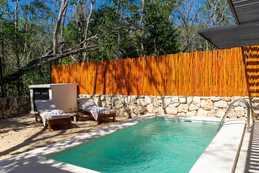 Brand NEW! Tulum Jungle Villa with private pool في تولوم: مسبح في فناء خلفي مع سياج خشبي