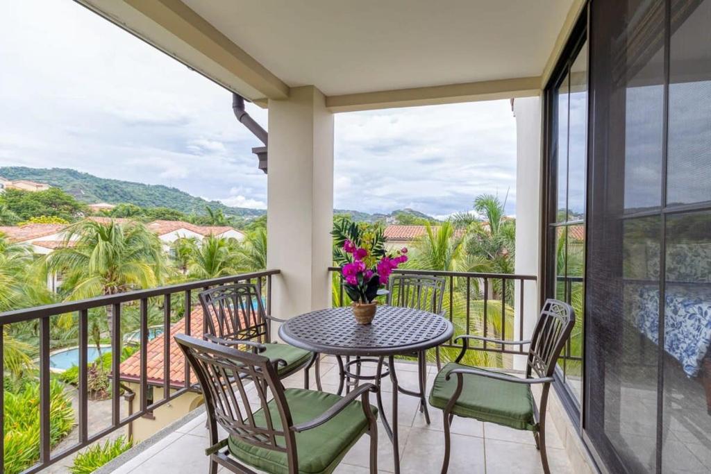 balcón con mesa, sillas y vistas en 3-Bedroom 2-Bath Condo Overlooking Pool en Coco