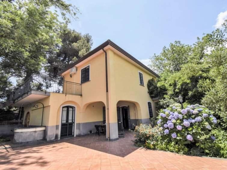 a large yellow house with a balcony and flowers at Villa Anna in Mascali