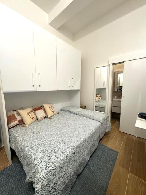 a white bedroom with a bed and a mirror at Casa Manú centro Bologna in Bologna
