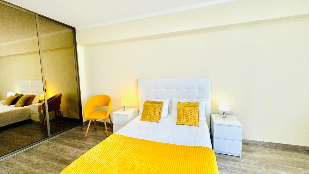 1 dormitorio con 1 cama grande con almohadas amarillas en Praia da Rocha, 5-F, Charming Apartment with Air Conditioning - Pátio da Rocha By IG, en Portimão