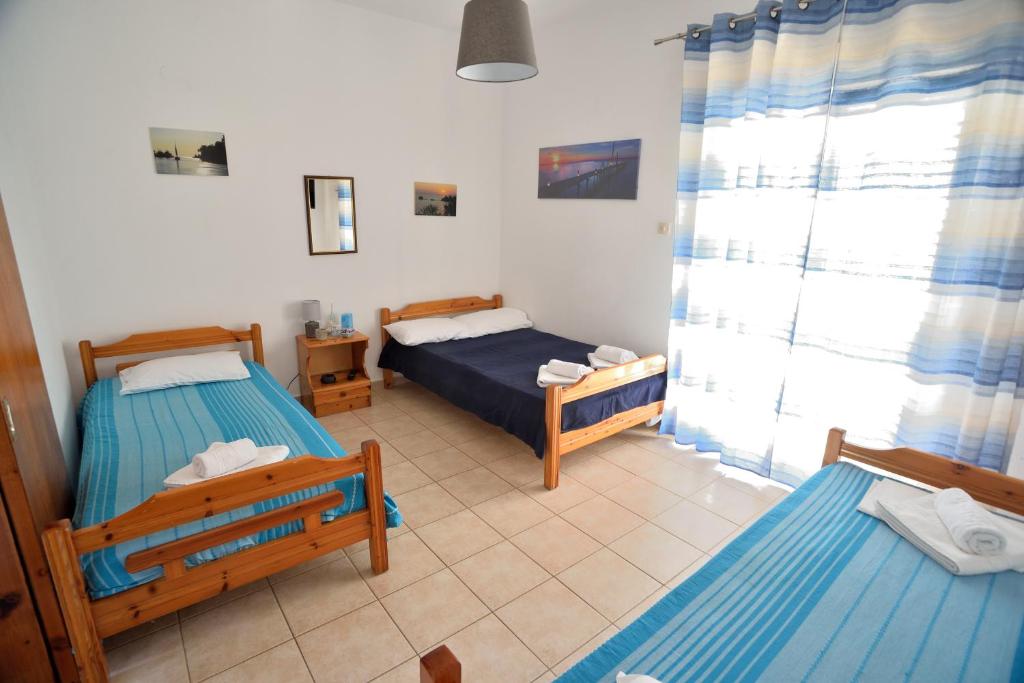 a small room with two beds and a window at Maria Konstantinidis Apartments in Nea Potidaea