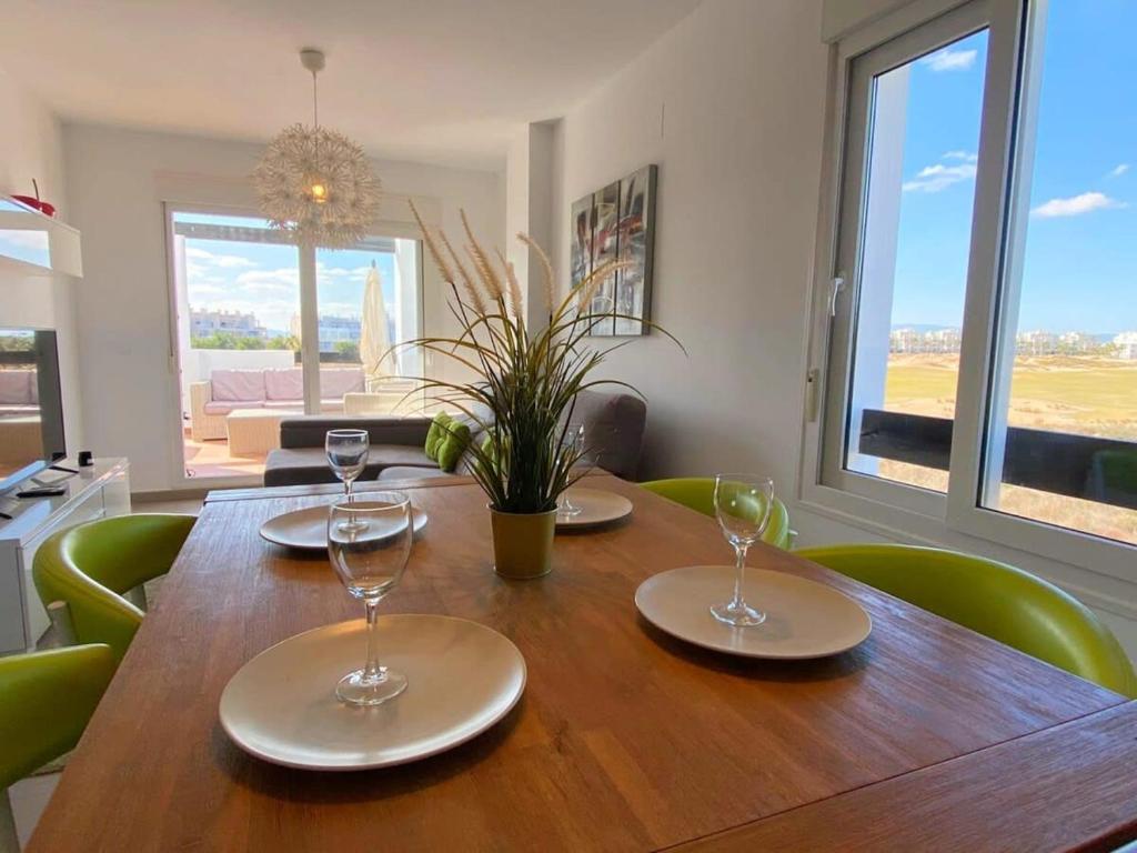 einen Esstisch mit vier Stühlen und Gläsern darauf in der Unterkunft Lovely two bedroom Pool & Golf Apartment - SA928LTZ in Roldán
