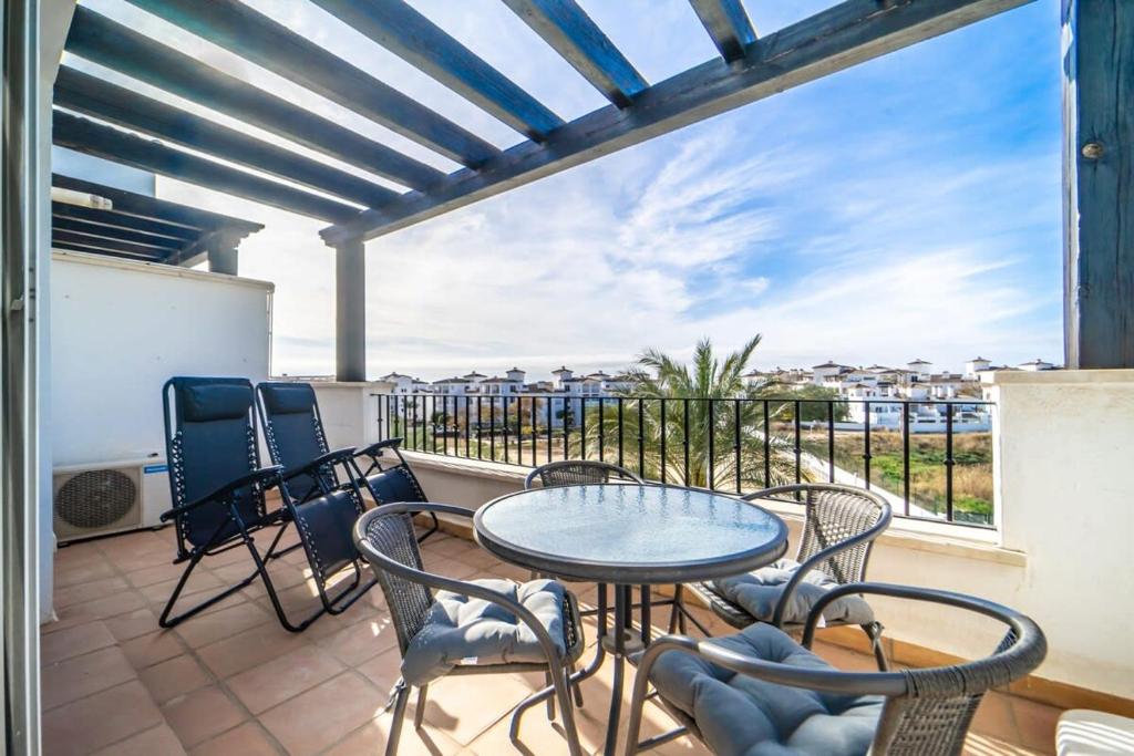 eine Terrasse mit einem Tisch und Stühlen auf dem Balkon in der Unterkunft Sunny apartment at La Torre Golf Resort - AO3031LT in Torre-Pacheco