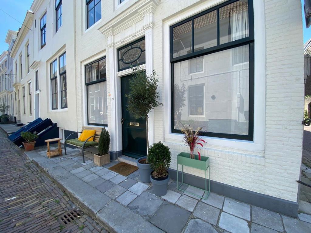 un edificio blanco con plantas delante en Hello Zeeland - Appartement Molstraat 23, en Middelburg