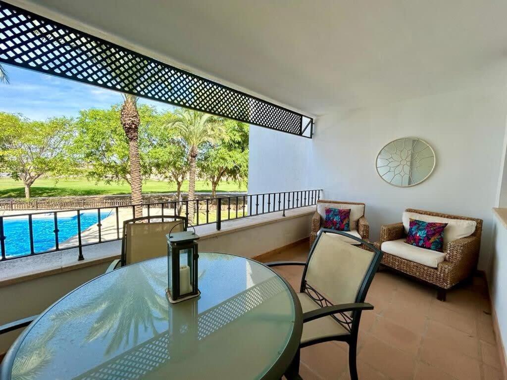 une salle à manger avec une table et des chaises en verre dans l'établissement Apartment with pool & golf views - AA2711LT, à Roldán