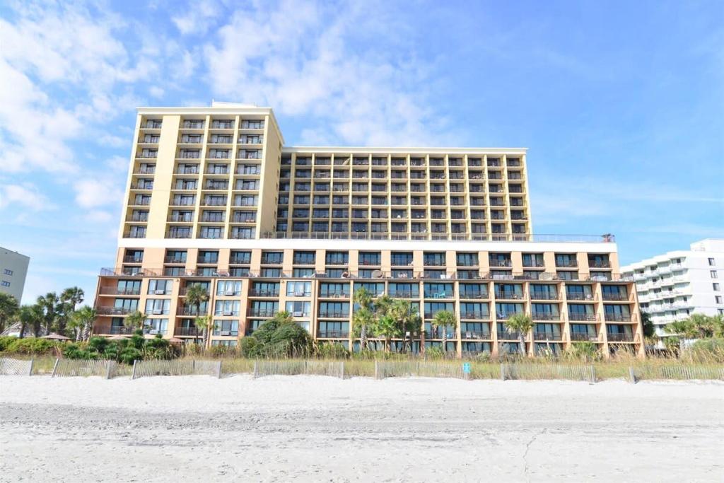 un gran edificio con una playa frente a él en Pool View Oceanfront Caravelle Resort w Lazy River, en Myrtle Beach