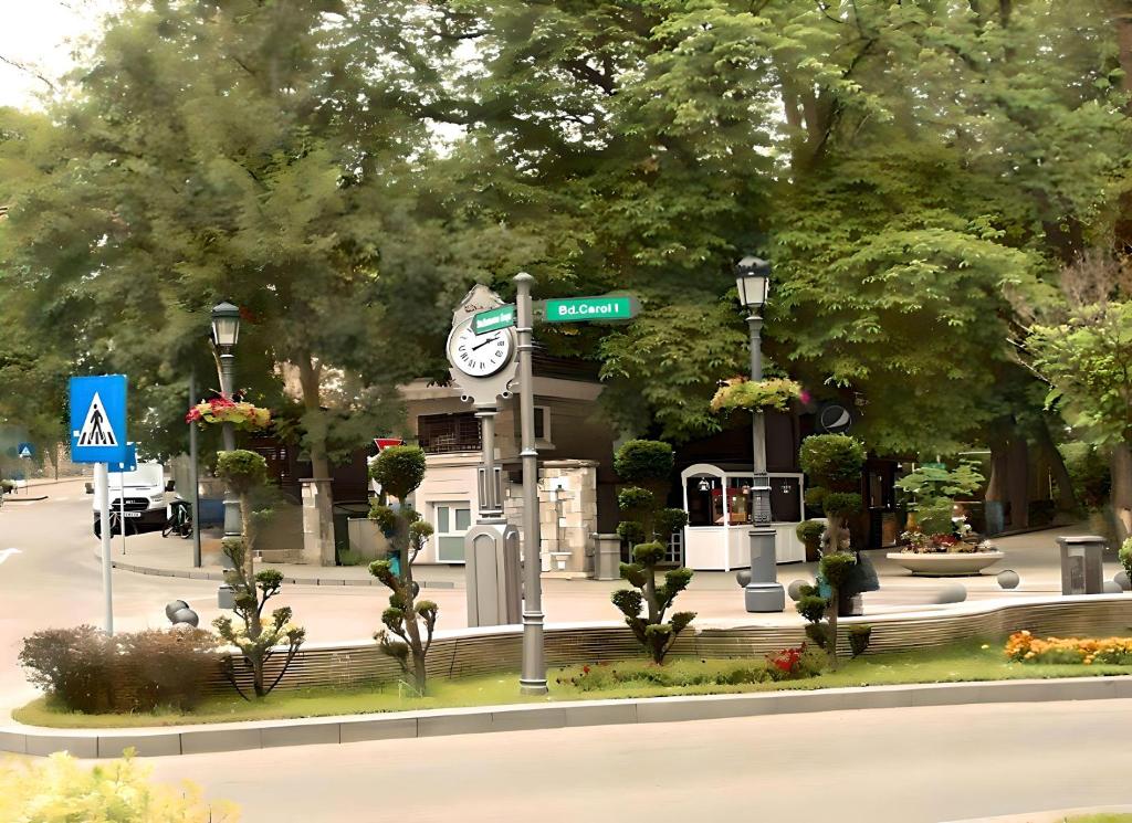 un montage d'un bâtiment avec une horloge et un panneau indiquant la rue dans l'établissement Sinaia Central Park, à Sinaia