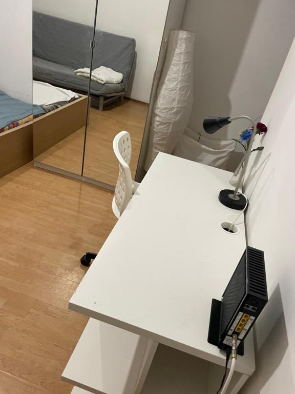 a white desk with a computer and a bed at KFlat Stay in Budapest