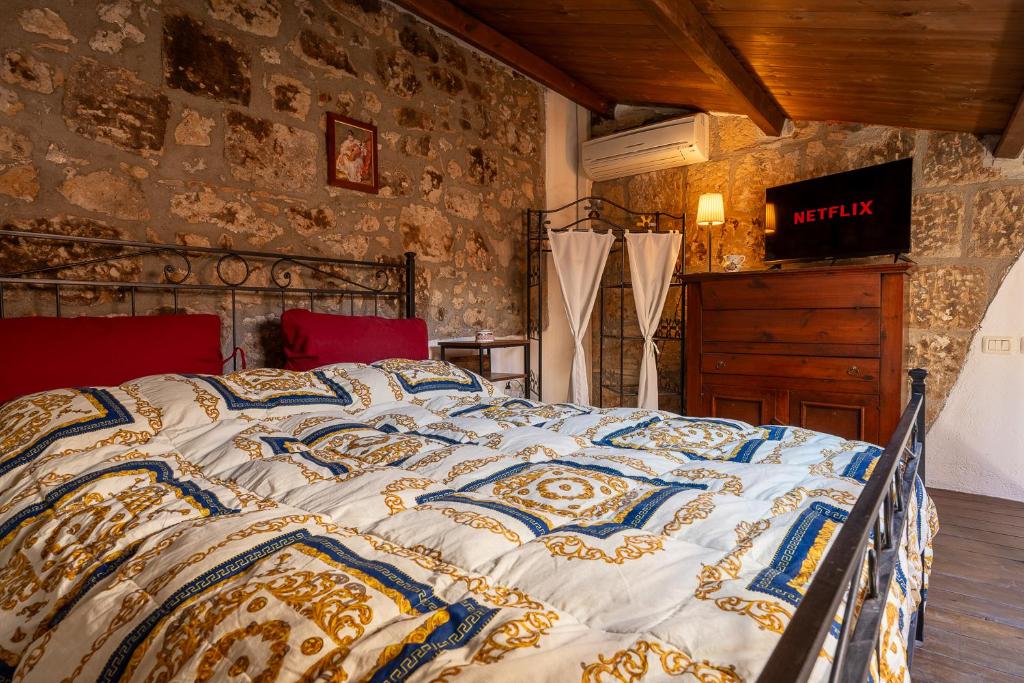 Cama grande en habitación con pared de piedra en Your luxury room Civitella, en Civitella dʼAgliano