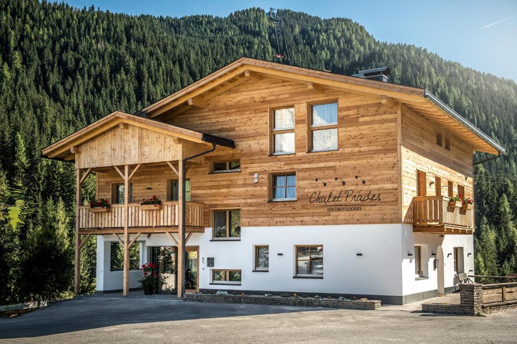 een blokhut met een balkon aan de zijkant bij Chalet Prades Dolomiti Lodges in La Villa