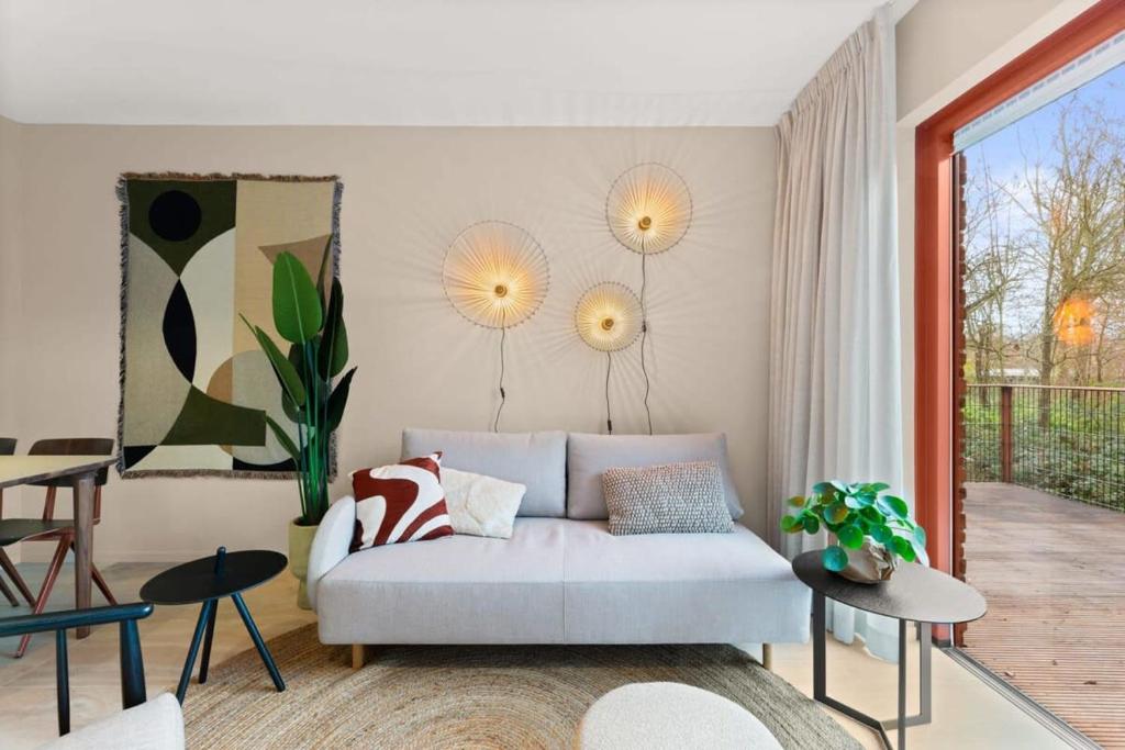 uma sala de estar com um sofá e uma mesa em Hello Zeeland - Appartement Duinenburg 10- 3 em Domburg