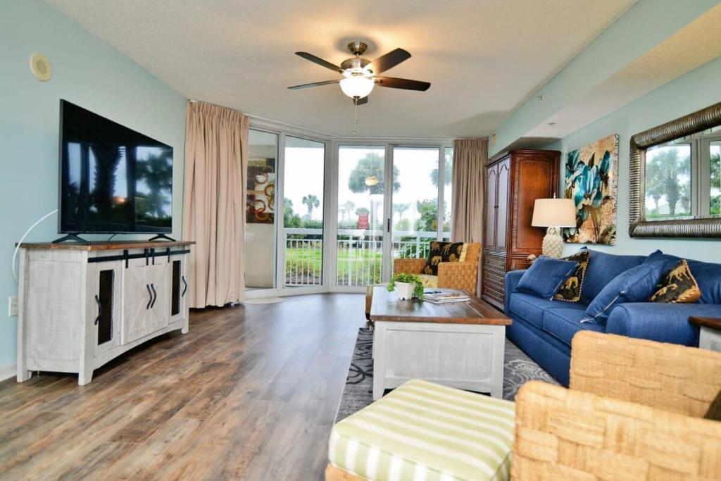 ein Wohnzimmer mit einem blauen Sofa und einem Fernseher in der Unterkunft Waterfront Luxury Huge Condo with 15000sf Pool in Myrtle Beach