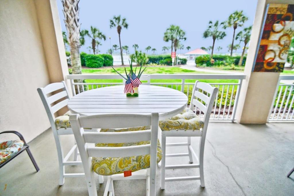 einen weißen Tisch und Stühle auf einer Veranda in der Unterkunft Waterfront Luxury Huge Condo with 15000sf Pool in Myrtle Beach