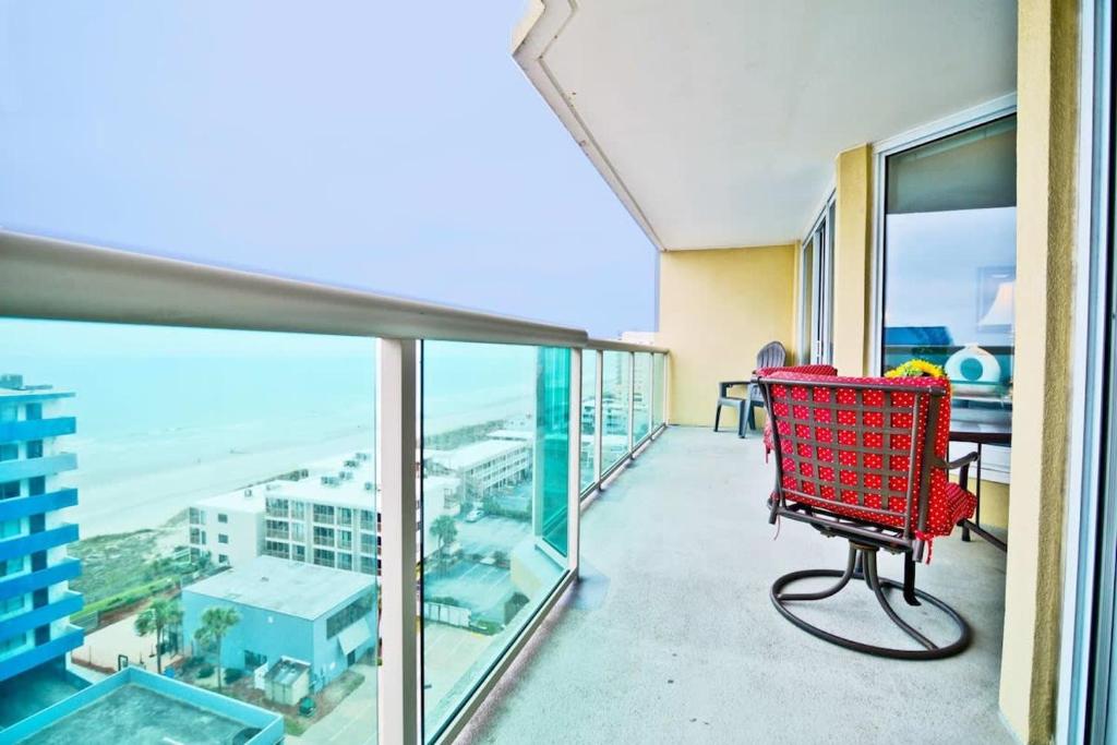 une chaise rouge sur le balcon d'un bâtiment dans l'établissement Ocean View All New Malibu Pointe Dream, à Myrtle Beach