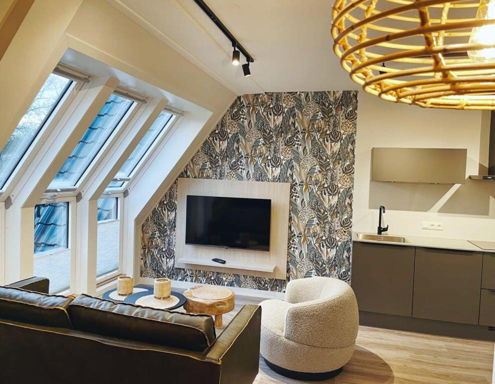 salon z kanapą i telewizorem w obiekcie Hello Zeeland - Appartement Duno Lodge L w mieście Oostkapelle