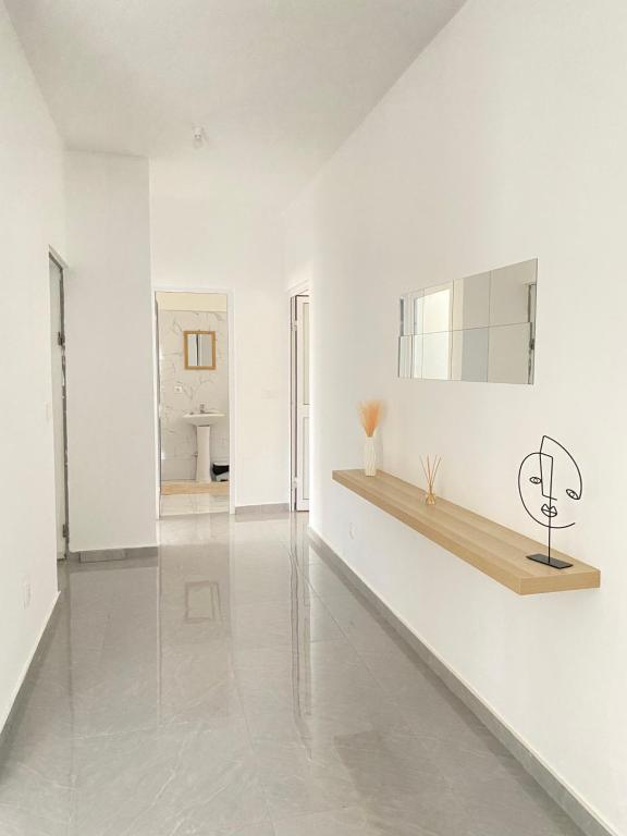 a white room with a shelf and a mirror on the wall at Vila de Santiago Apartment in Pedra Badejo