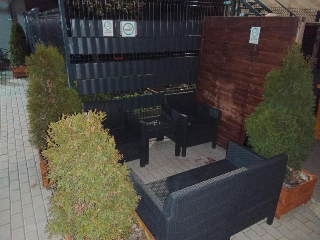 eine Terrasse mit schwarzen Sofas und Sträuchern in der Unterkunft Gościnne mieszkania M2 in Białystok