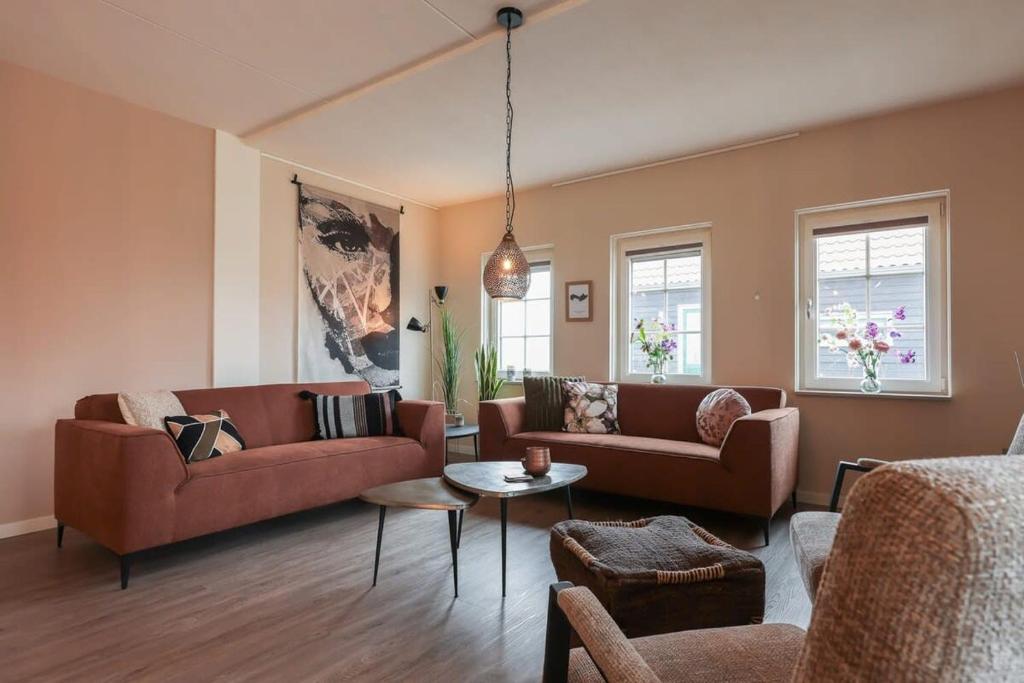 a living room with two couches and a table at Hello Zeeland - vakantiewoning Knuitershoek 66 
