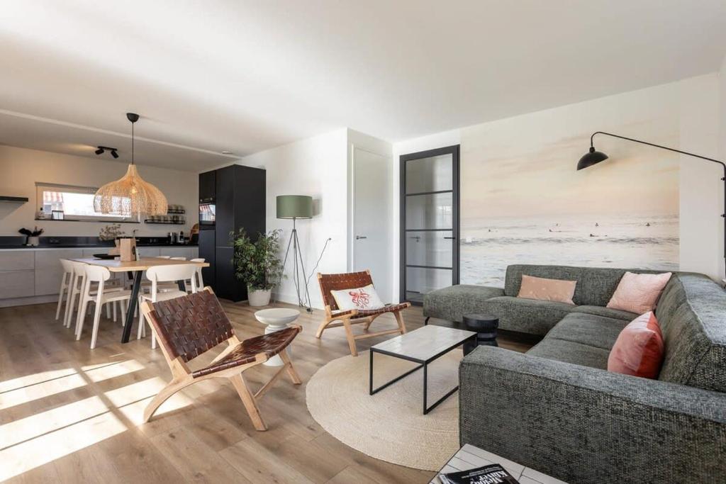 a living room with a couch and a table at Hello Zeeland - vakantiewoning Knuitershoek 72 in Kloosterzande