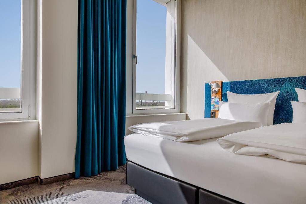Postel nebo postele na pokoji v ubytování Motel One München-Campus