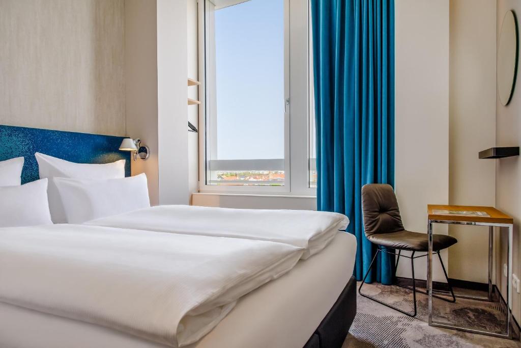 Postel nebo postele na pokoji v ubytování Motel One München-Campus