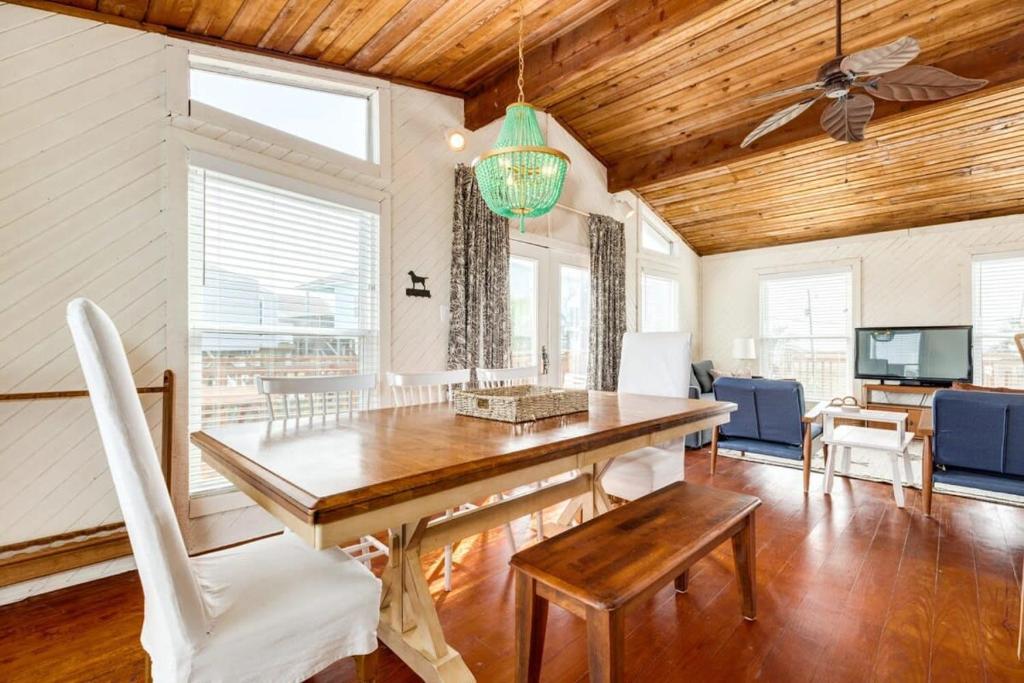 a dining room with a table and a ceiling fan at Beechwood Bungalow - Where Comfortable Coastal and Calm Meet Waves Water and WOW in Freeport