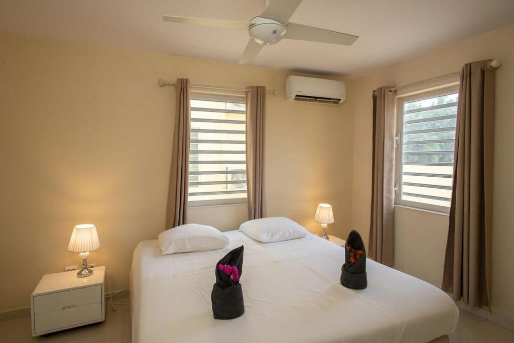 - une chambre dotée d'un lit avec des chaussures noires dans l'établissement Caracara J4 Relax & Dive Resort Bonaire Village, à Kralendijk