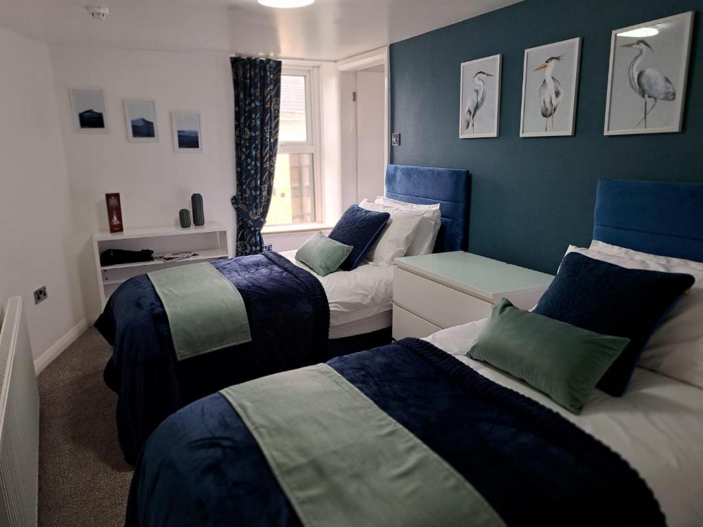 2 letti in una camera con blu e bianco di Old Sun Hotel a Haworth