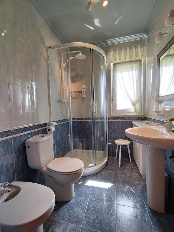 łazienka z prysznicem, toaletą i umywalką w obiekcie Complexo Alameda w mieście Viveiro