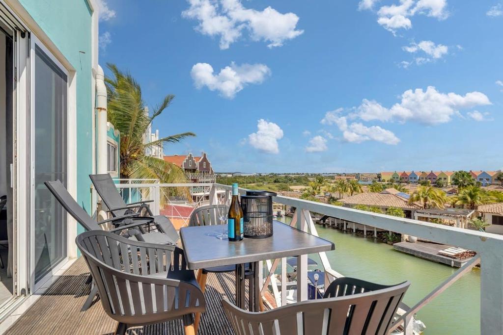 a table and chairs on a balcony with a view of the water at Caribbean Court Studio 321 in Kralendijk