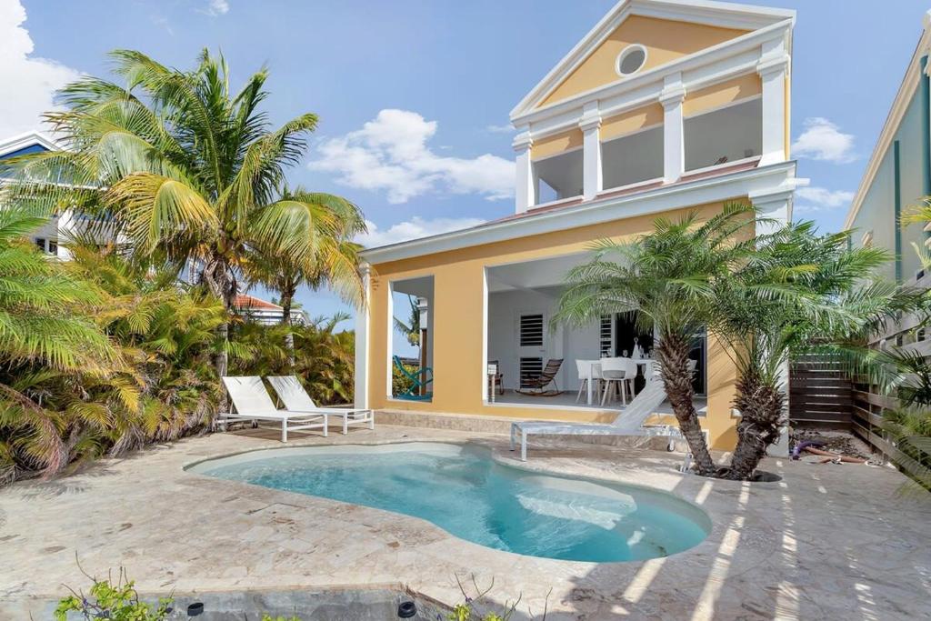 a house with a swimming pool in front of a house at Casa Leeward with Pool on the Laguna Marina in Kralendijk