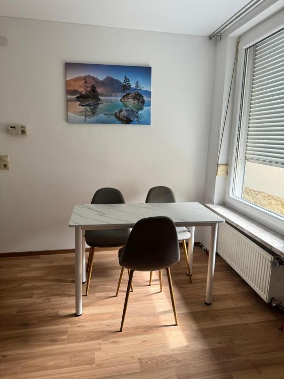 une table à manger avec deux chaises et un tableau mural dans l'établissement Ferienwohnung Montuerwohnung Naila, à Naila