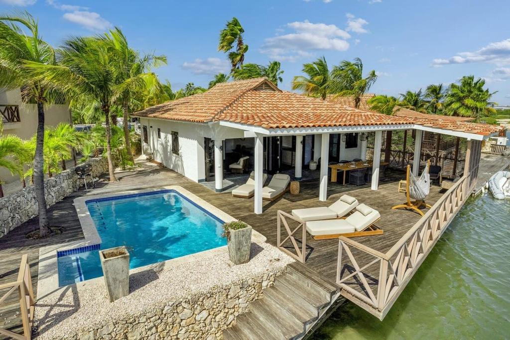 eine Villa mit Swimmingpool und ein Haus in der Unterkunft Costa de la Luz on the water of the Laguna Marina in Kralendijk