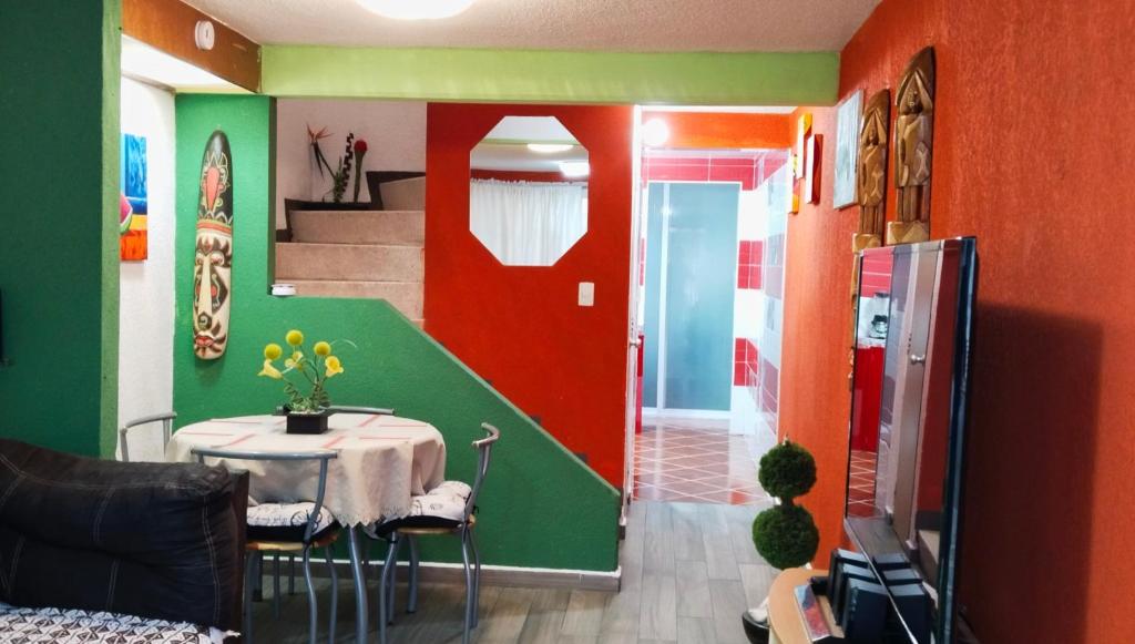 a dining room with a table and a red and green wall at Llegaste a casa almendros in Santa Cruz Tecamac