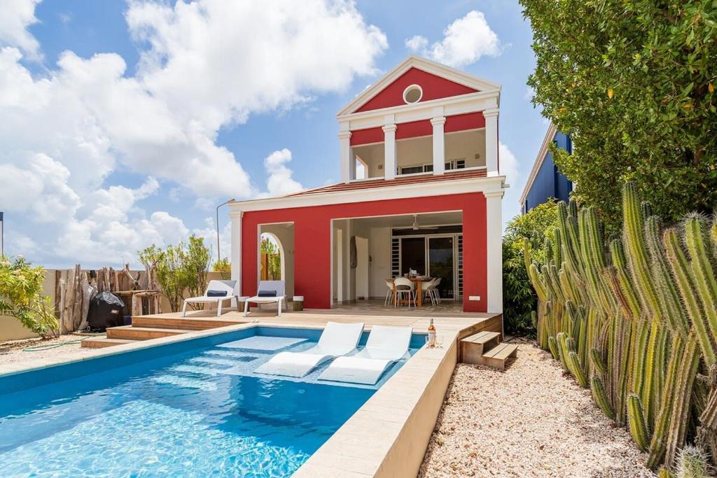 eine Villa mit einem Pool und einem Haus in der Unterkunft Kas Dive-In with Private Pool on the Laguna Marina in Kralendijk