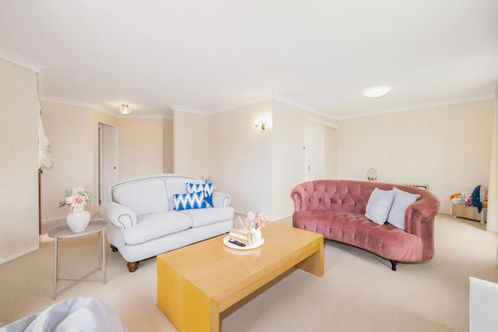 a living room with a couch and a table at Spacious 3-BR Haven Prime Location Shopping Centre in Algester
