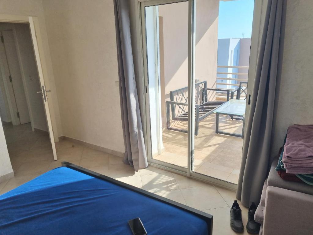 een kamer met een glazen schuifdeur en een balkon bij Résidence tafoult imi ouadar in Agadir nʼ Aït Sa