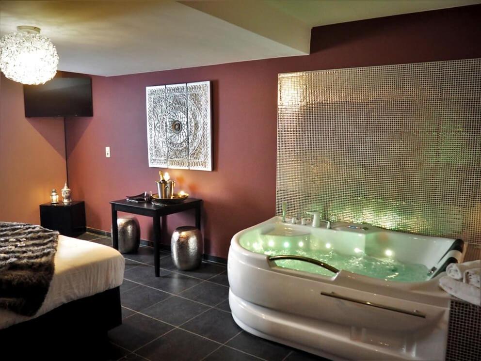a large bathroom with a tub and a bed at Symbiose hotel in Charleroi