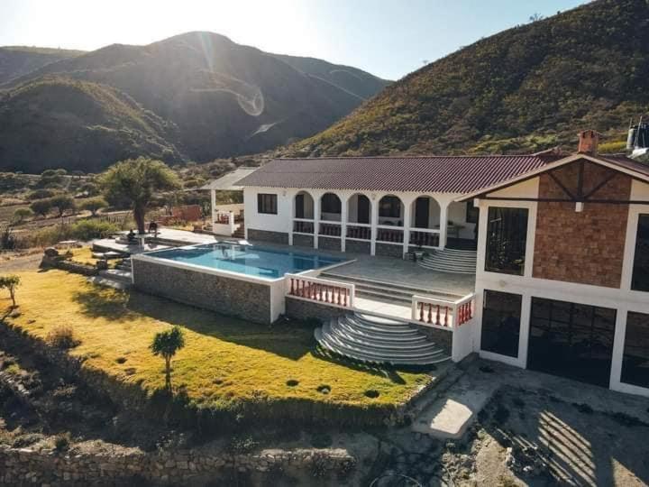 una casa con piscina di fronte a una montagna di Hacienda QuespiLlajta a Sucre