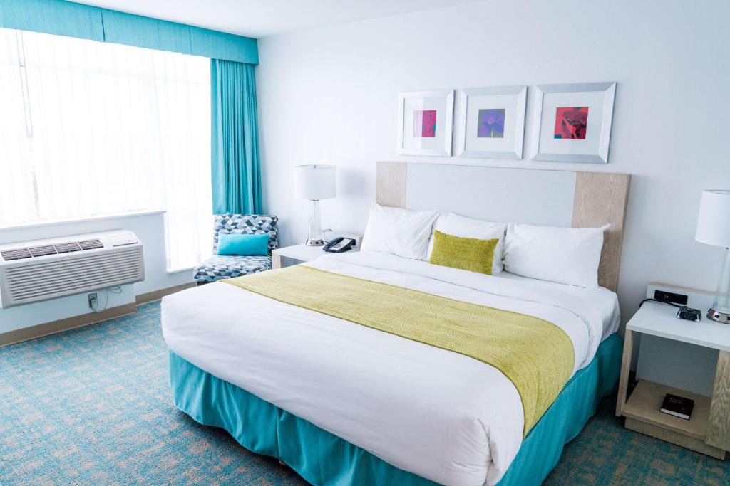 a hotel room with a large bed and a window at Coast Hotel & Convention Centre in Langley