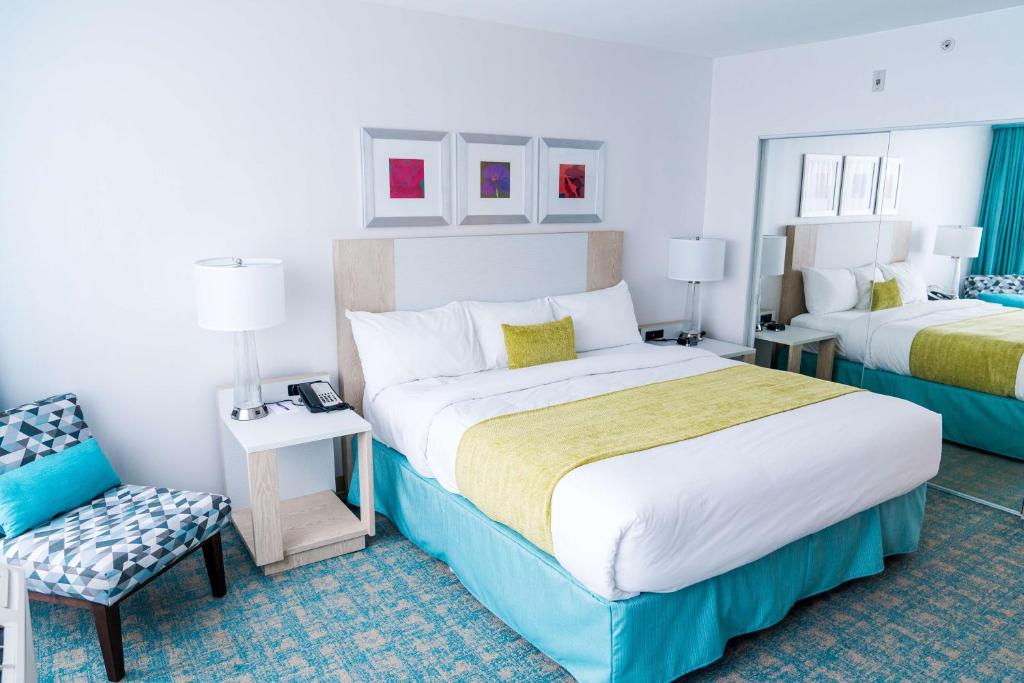 a hotel room with two beds and a chair at Coast Hotel & Convention Centre in Langley