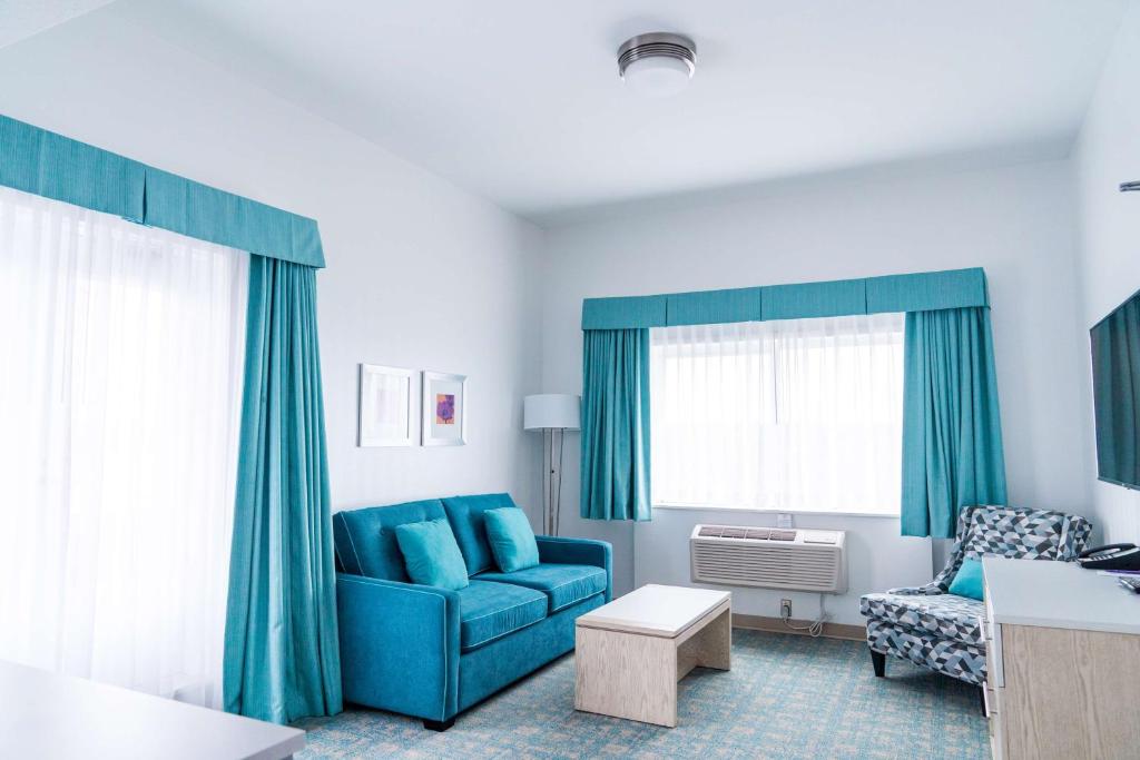 a living room with a blue couch and a chair at Coast Hotel & Convention Centre in Langley