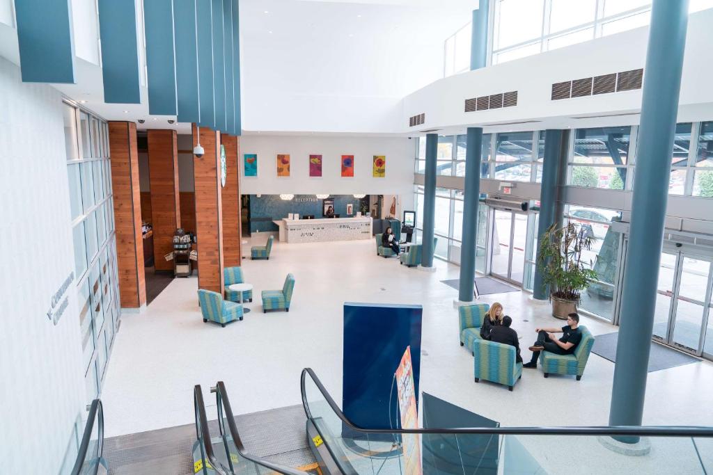 two people sitting in chairs in the lobby of a building at Coast Hotel & Convention Centre in Langley