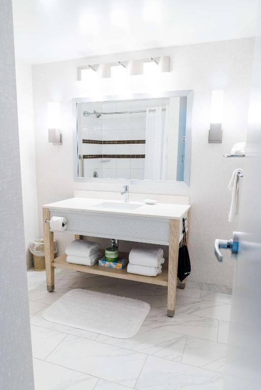 a white bathroom with a sink and a mirror at Coast Hotel & Convention Centre in Langley